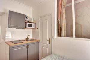 a small kitchen with a sink and a microwave at Les Petits Boudoirs de Savoie in Chambéry +16 photos