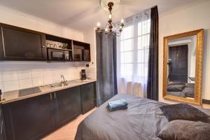 a bedroom with a bed and a sink and a mirror at Les Petits Boudoirs de Savoie in Chambéry