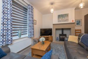 a living room with a couch and a fireplace at Sleeps 6 4 bedrooms 2 minute walk to the Square Hosted Happy Valley Cast in Hebden Bridge