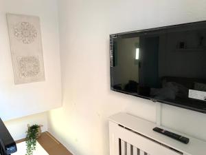 een flatscreen-tv aan een witte muur bij Casita Menta - Alojamiento único en el Centro de Torrox in Torrox