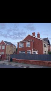 uma casa de tijolos vermelhos com uma cerca em frente em Danny holiday home em Blackpool