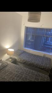 a bedroom with a bed and a blue window at Danny holiday home in Blackpool