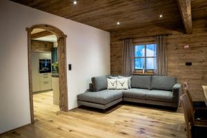 uma sala de estar com um sofá e uma janela em Müllner Appartements em Thiersee