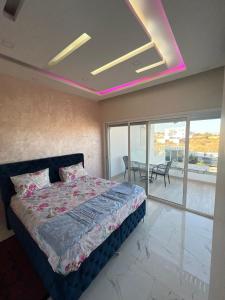 Schlafzimmer mit einem Bett mit rosa Licht an der Decke in der Unterkunft Diamond House in Saly Portudal