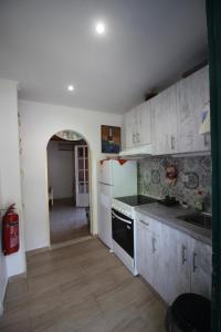 a kitchen with white cabinets and a stove top oven at Niky's cottage in Paleokastritsa