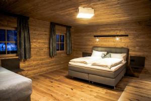 1 dormitorio con 1 cama en una habitación con paredes de madera en Müllner Appartements en Thiersee