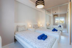 a bedroom with two beds with blue pillows on them at Seafront 2 bedroom apart with air con and garage in Armação de Pera in Armação de Pêra