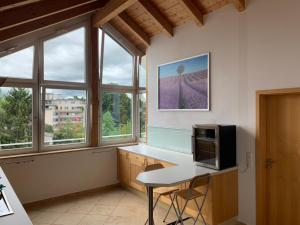 a kitchen with windows and a table with a microwave at City Dachterassenwohnung in Rosenheim