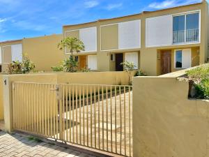 a yellow house with a fence in front of it at Maria da Vinha Porto Santo Beach House in Porto Santo