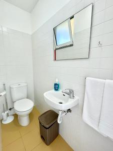 bagno con servizi igienici, lavandino e specchio di Maria da Vinha Porto Santo Beach House a Porto Santo