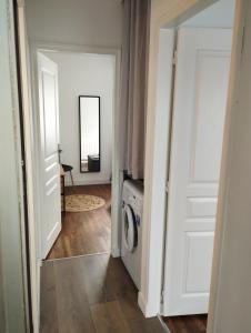 un couloir avec un lave-linge et un miroir dans l'établissement Ma maison de vacances en Bretagne, à Meillac