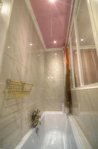 La salle de bains est pourvue d'une baignoire et d'un lavabo. dans l'établissement Les Petits Boudoirs de Savoie, à Chambéry