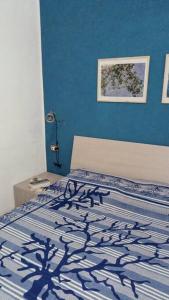 een slaapkamer met een bed met een blauwe muur bij CASA FIORITA in Rodi Garganico