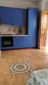 a kitchen with blue cabinets and a wooden floor at CASA FIORITA in Rodi Garganico