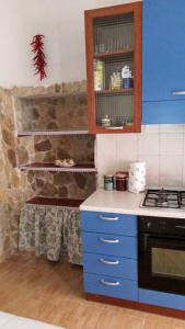 a kitchen with blue cabinets and a stone wall at CASA FIORITA in Rodi Garganico