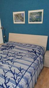 1 dormitorio con 1 cama con pared azul en CASA FIORITA en Rodi Garganico