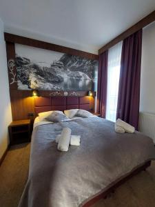 a bedroom with a large bed with towels on it at Willa U Kośle 2 in Zakopane
