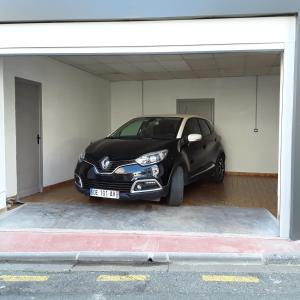 a black car parked inside of a garage at MAISON DE VILLE AVEC GARAGE ET TERRASSE in Lourdes