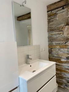 baño con lavabo y pared de piedra en APPARTEMENT CENTRE HISTORIQUE - Lannion, en Lannion