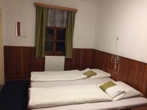 two twin beds in a room with a window at Chata Čert in Josefuv dul