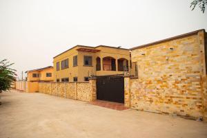 a brick building with a gate and a garage at Urban Condos in Accra
