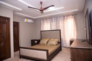 1 dormitorio con 1 cama y ventilador de techo en Urban Condos, en Accra