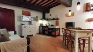 sala de estar con mesa y cocina en Casa Vacanze Carducci en San Casciano dei Bagni