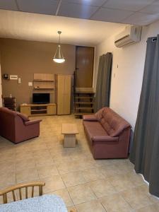 una sala de estar con 2 sofás de cuero y una mesa. en GELMIF Apartments, en Birgu