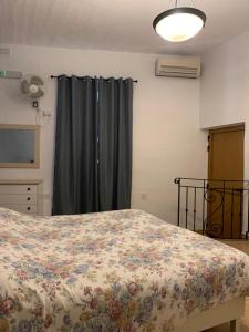um quarto com uma cama com um edredão floral em GELMIF Apartments em Vittoriosa