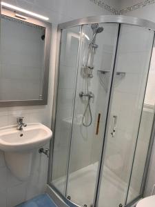 uma casa de banho com um chuveiro e um lavatório. em GELMIF Apartments em Vittoriosa