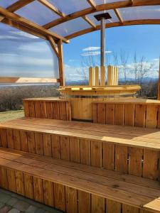 eine Holzterrasse mit einer Pergola und einem Tisch in der Unterkunft Domki na Górniej Łące - Dwa Wróble in Łazany