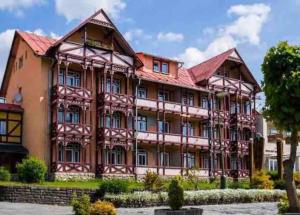 a large wooden building with a red roof at Apartmán PEPO Smokovec in Starý Smokovec