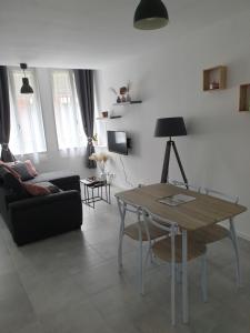 uma sala de estar com uma mesa e um sofá em Maison complete, jusqu a 6 personnes em Le Cateau