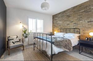 a bedroom with a bed and a brick wall at No.1 Universal House - Double Bedroom Apartment in Bromley