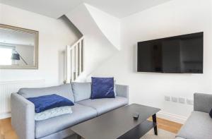 a living room with a couch and a tv at No.1 Universal House - Double Bedroom Apartment in Bromley