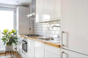 ブロムリーにあるNo.1 Universal House - Double Bedroom Apartmentの白いキッチン(白いキャビネット、シンク付)