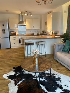 a living room with a table and a kitchen at Luxury Riverfront Apartment in Newport