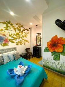 a room with a bed with a flower painted on the wall at Hotel boutique stay la 10 in Medellín