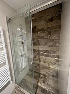 a shower in a bathroom with a stone wall at DELUXE Apartment Newsky with terrace in Belgrade