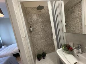bagno con doccia, lavandino e specchio di Dal Ciandri a Pisa