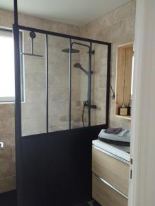 La salle de bains est pourvue d'une douche avec une porte en verre. dans l'établissement Ma maison de vacances en Bretagne, à Meillac