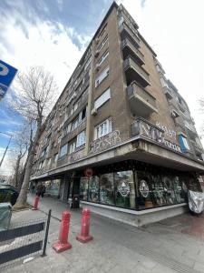 a building on a street with a red fire hydrant in front at DELUXE Apartment Newsky with terrace in Belgrade