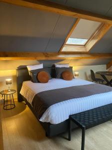 a bedroom with a large bed in a attic at Au Refuge du Bois in Walhain-Saint-Paul