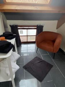 Au Refuge du Bois في Walhain-Saint-Paul: غرفة معيشة مع كرسي ونافذة