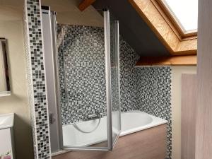 a bathroom with a shower and a bath tub at Au Refuge du Bois in Walhain-Saint-Paul +9 photos