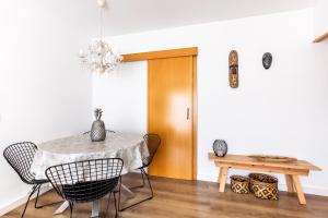 comedor con mesa, sillas y lámpara de araña en Casa Natura Gava Beach en Barcelona