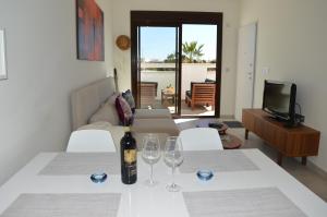 Zimmer mit einem Tisch mit Weingläsern und einem Sofa in der Unterkunft Comfortable Apartment in Torre de la Horadada in Torre de la Horadada