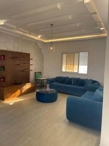 uma sala de estar com um sofá azul e uma mesa em Magnifique villa vue mer em El Mida