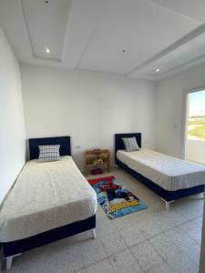 um quarto com 2 camas e um tapete em Magnifique villa vue mer em El Mida