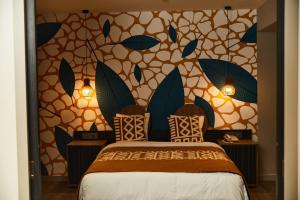 阿比让ONOMO Hotel Abidjan的一间卧室设有床,墙上有树叶